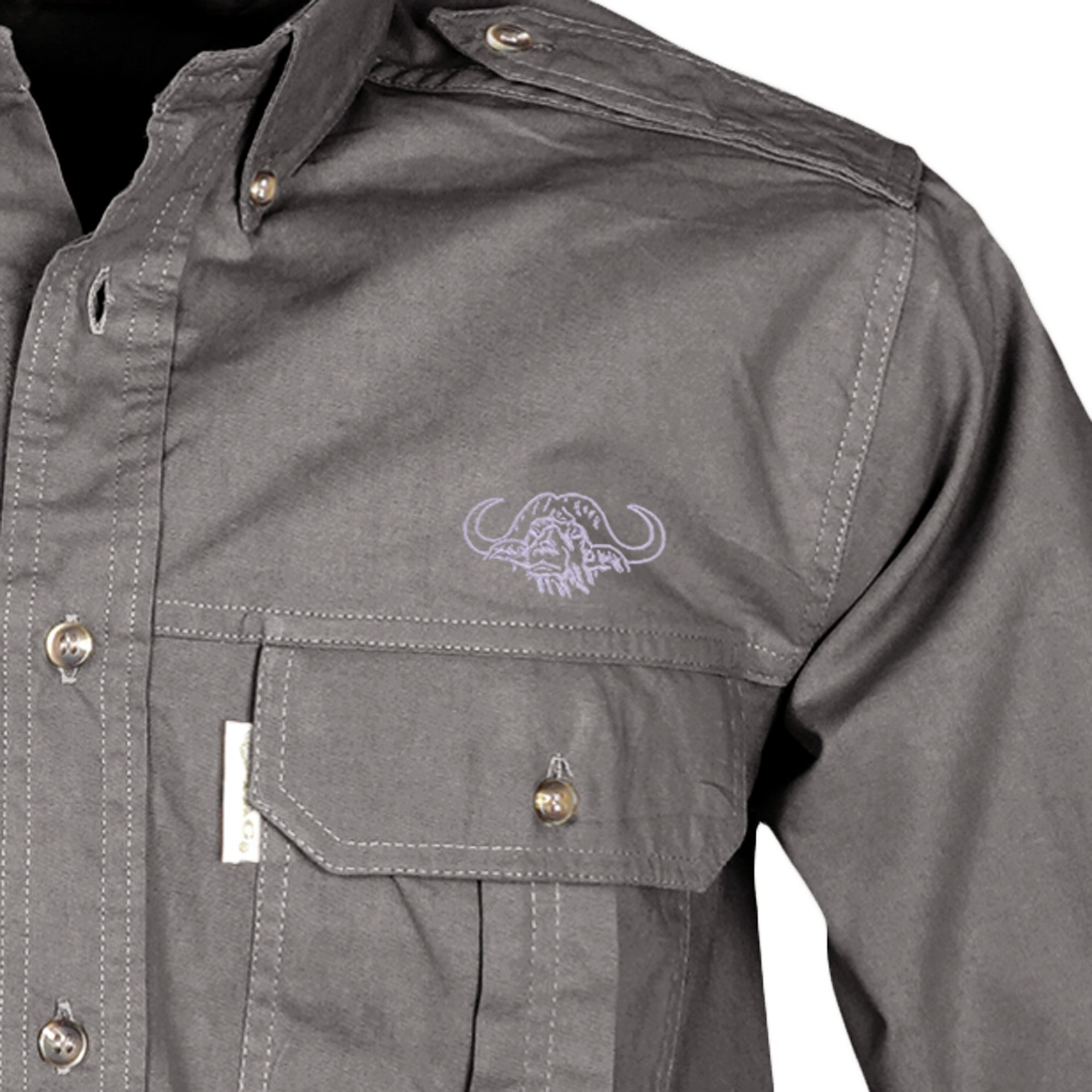 Closeup of a Men's Trail Shirt with Buffalo Logo in Long Sleeves, color Olive. The shirt has a flap-covered chest pocket on the left side with an embroidered Tag buffalo logo above, button-down collars, functional cross-stitched shoulder straps, a button-front placket, and double stitching throughout. 100% cotton.--6